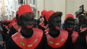 In Spanje ligt de zwartgeschminkte Balthazar, die optreedt in het kerstverhaal als één van de wijzen uit het oosten, onder vuur. Bron: RT Ruptly